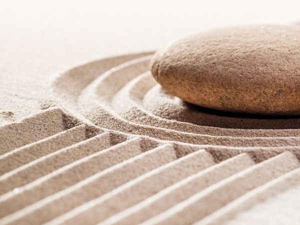 A single smooth stone on raked sand