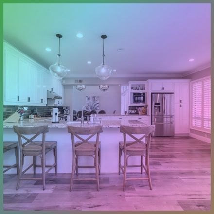 Kitchen with an island and three stools under an iridescent rainbow overlay